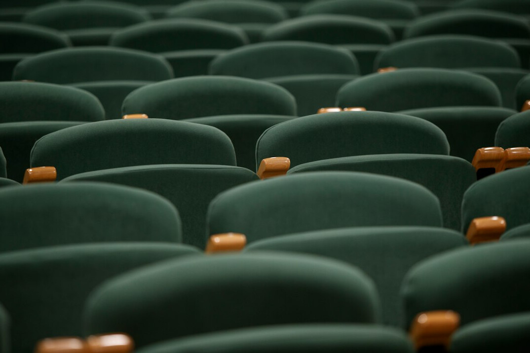 Rows of empty cinema seats facing a screen